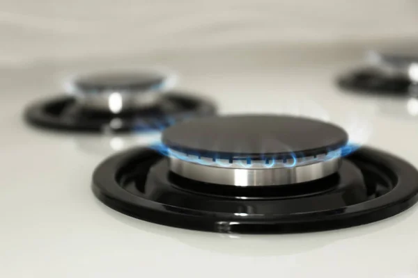 Gas burner with blue flame on modern stove, closeup — Stock Photo, Image