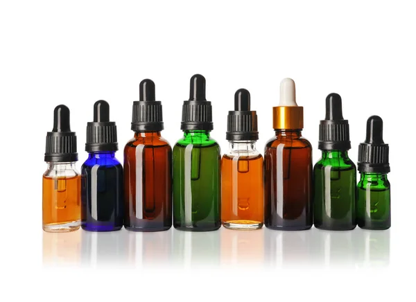 Kosmetické láhve základních olejů na bílém pozadí — Stock fotografie