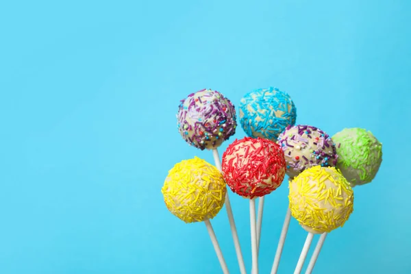 Yummy bright cake pops on color background. Space for text