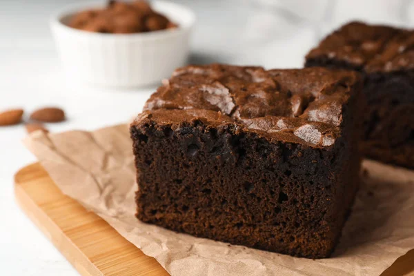 Ξύλινη σανίδα με φρέσκα brownies στο τραπέζι, χώρος για κείμενο. Νόστιμη σοκολατόπιτα — Φωτογραφία Αρχείου