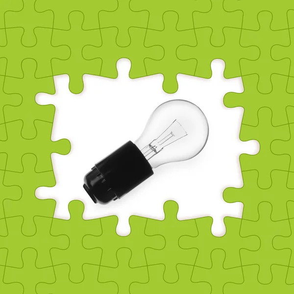 Heller Rahmen aus Puzzles und Glühbirne auf weißem Hintergrund — Stockfoto