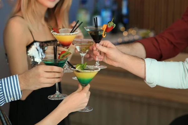 Группа молодых людей, держащих коктейли мартини на вечеринке, крупным планом — стоковое фото