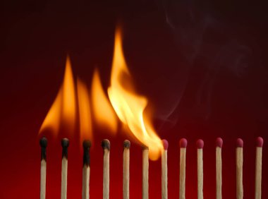 Line of burning matches on color background clipart