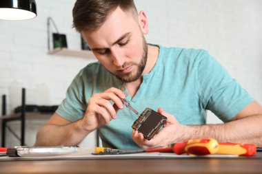 Atölyede masada cep telefonu tamir teknisyeni