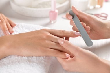 Manikürcü, masadaki müşterinin tırnaklarını, yakın çekim. Spa tedavisi