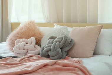 Farklı yastıklar ve hafif odada ekose ile rahat yatak. İç dekor için fikir