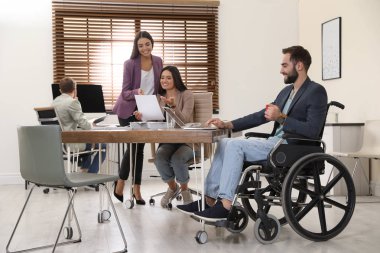 Tekerlekli sandalyeye mahkum işyerinde meslektaşları ile genç adam