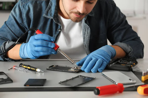 Técnico reparación de teléfonos inteligentes rotos en la mesa, primer plano —  Fotos de Stock