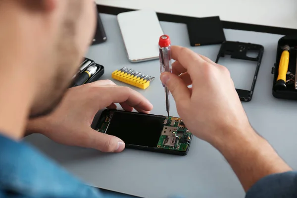 Técnico reparar smartphone quebrado na mesa, close-up — Fotografia de Stock