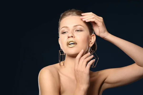 Retrato de hermosa dama con lápiz labial de oro sobre fondo de color — Foto de Stock