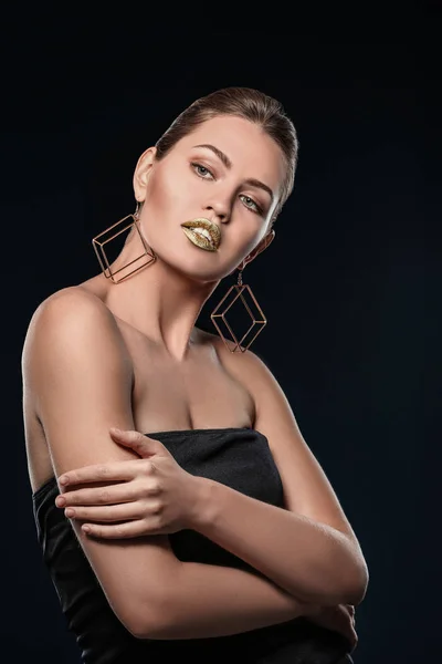 Retrato de hermosa dama con lápiz labial de oro sobre fondo negro — Foto de Stock