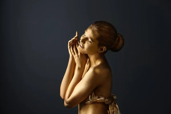 Retrato de bela senhora com tinta dourada na pele contra fundo cinza — Fotografia de Stock
