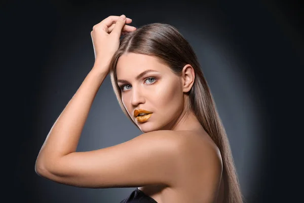 Retrato de bella dama con lápiz labial dorado sobre fondo gris — Foto de Stock