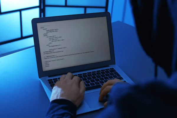 Homem usando laptop à mesa em quarto escuro, close-up. Infracção penal — Fotografia de Stock