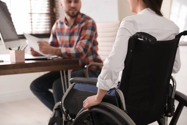 Kobieta na wózku inwalidzkim z kolegą w miejscu pracy, zbliżenie — Zdjęcie stockowe