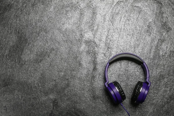 Auriculares elegantes sobre fondo gris, vista superior. Espacio para texto — Foto de Stock