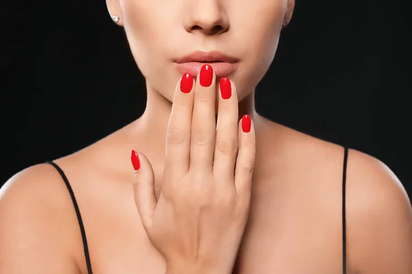 Beautiful young woman with bright manicure on black background, closeup. Nail polish trends — Stock Photo, Image