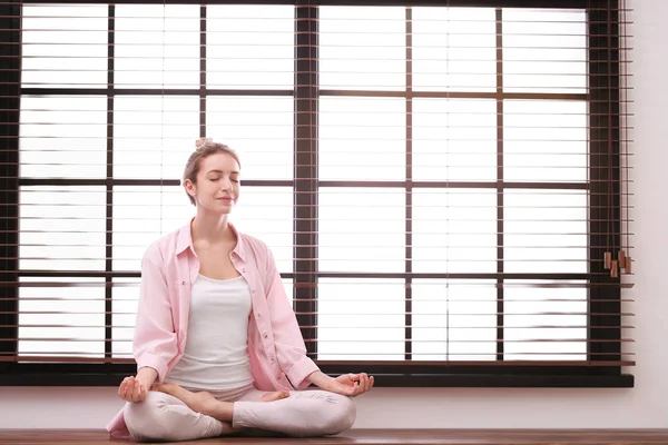 Mujer joven meditando en casa, espacio para el texto. Concepto zen — Foto de Stock