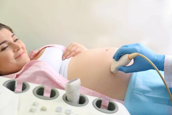 Jovem grávida submetida a ultra-som na clínica — Fotografia de Stock