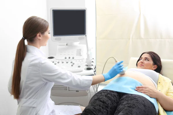 Ultrason taramada klinik geçiren genç hamile kadın — Stok fotoğraf