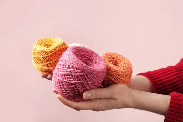 stock image Woman holding clews of threads against color background, closeup