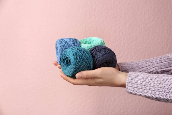 Woman holding clews of threads against color background, closeup — 스톡 사진