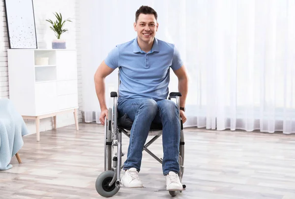 Glücklicher Mann sitzt im Rollstuhl zu Hause — Stockfoto