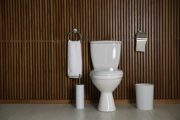 Простий інтер'єр ванної кімнати з новим туалетом біля дерев'яної стіни. Простір для тексту — стокове фото