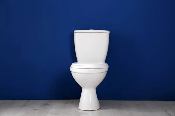 New toilet bowl near color wall indoors — Stock Photo, Image