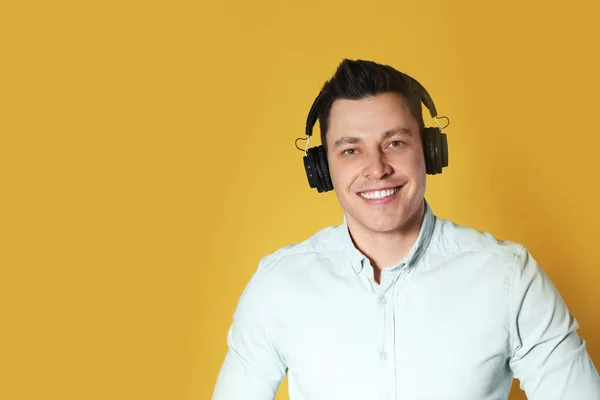 Man enjoying music in headphones on color background. Space for text — Stock Photo, Image