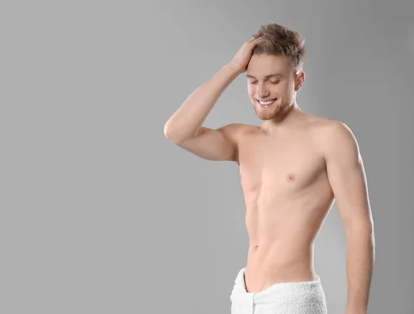 Retrato de jovem com corpo magro em toalha sobre fundo cinza. Espaço para texto — Fotografia de Stock