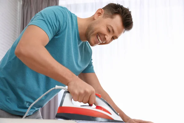 Man ironing shirt on board at home — Stock Photo, Image