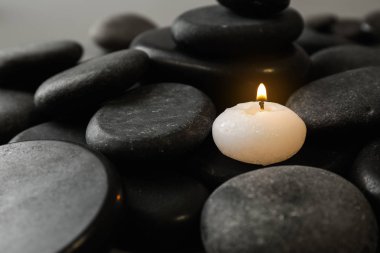 Güzel Spa taşlar üzerinde küçük yanan mum, metin için alan