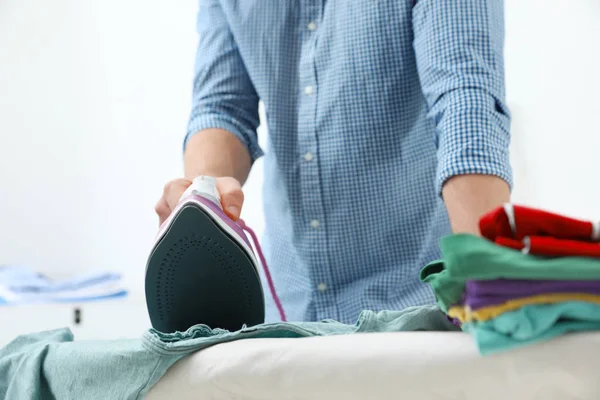 Hombre planchando ropa a bordo en casa, primer plano — Foto de Stock