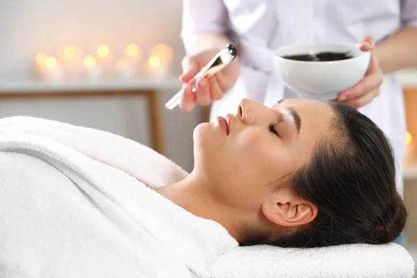 Cosmetologist aplicando máscara no rosto da mulher no salão de spa — Fotografia de Stock