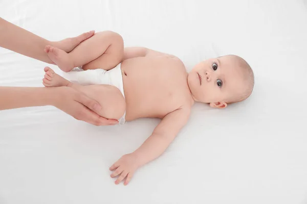 Mor och hennes söta barn på vita sängen, ovanför vyn. Baby massage och övningar — Stockfoto