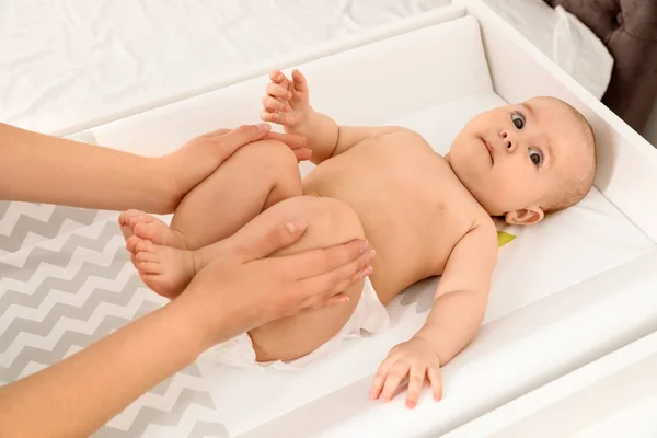 Mother and her cute child on changing table, above view. Baby massage and exercises — Stock Photo, Image