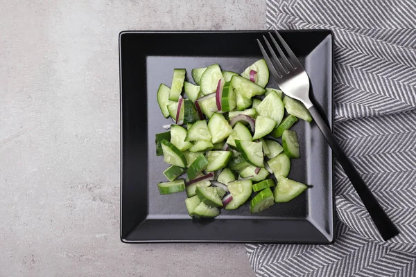 Assiette de salade végétarienne au concombre et à l'oignon servie sur table, mise à plat — Photo
