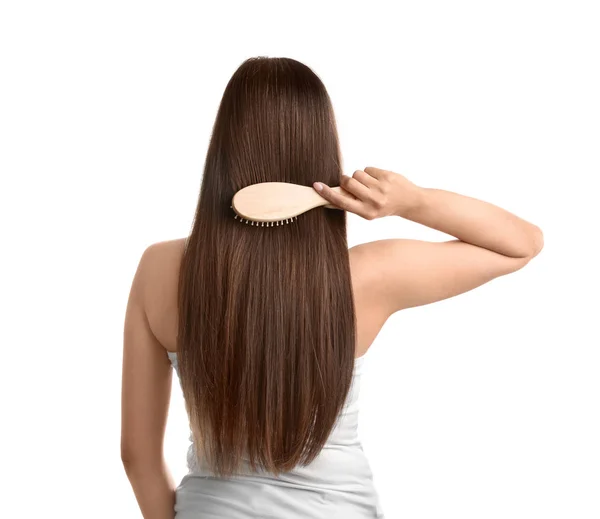 Visão traseira da jovem com escova de cabelo no fundo branco — Fotografia de Stock