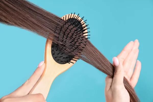 Woman with hair brush on color background, closeup — Stock Photo, Image