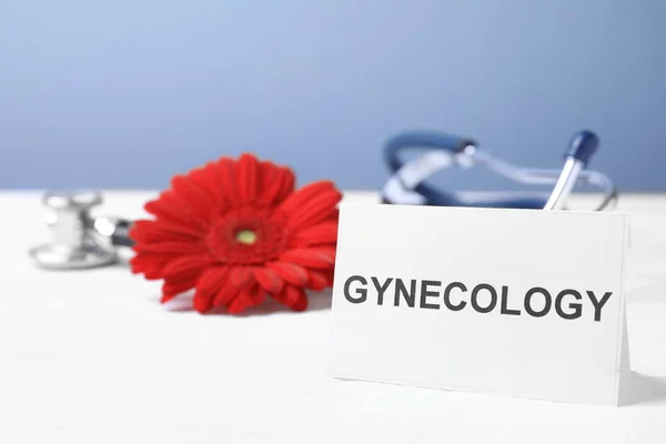 Carte avec mot Gynécologie, stéthoscope et fleur sur table — Photo