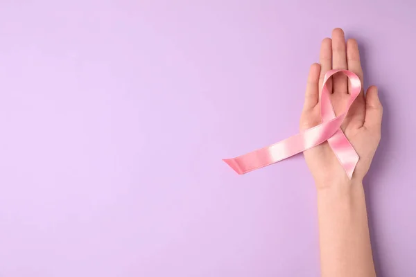 Donna con nastro simbolico di consapevolezza del cancro al seno e spazio per il testo su sfondo a colori, vista dall'alto. Cura ginecologica — Foto Stock