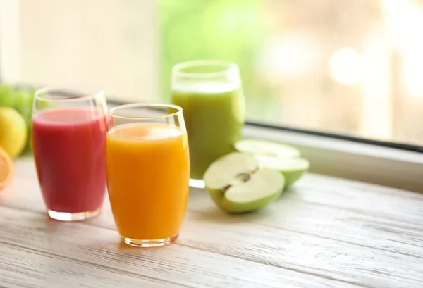 Glas med olika juicer och färsk frukt på träfönster brädan. Utrymme för text — Stockfoto