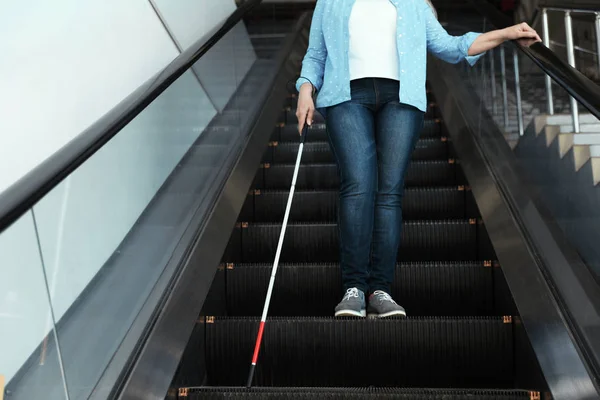 Blind person med lång käpp på rulltrappa inomhus — Stockfoto