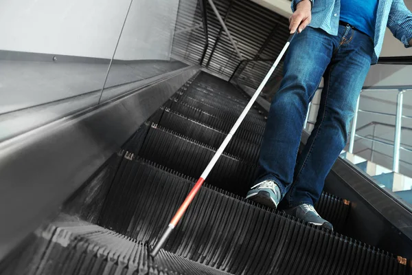 Persona ciega con bastón largo en escaleras mecánicas en interiores —  Fotos de Stock