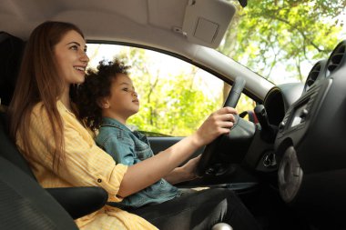 Sevimli küçük kızı ile anne birlikte araba sürme. Çocuk tehlikede