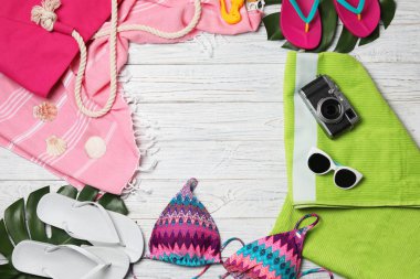 Ahşap arka plan üzerinde mayo ve plaj aksesuarları ile düz yatıyordu kompozisyon. Metin için alan