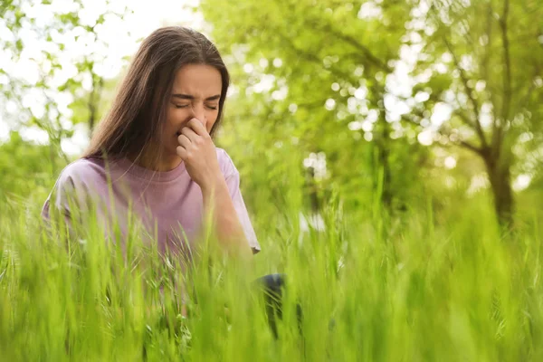 Jonge vrouw die lijdt aan seizoensgebonden allergie buitenshuis, ruimte voor tekst — Stockfoto