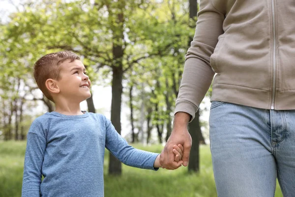 Aranyos kis gyermek kezében kezét az apjával a parkban. Családi idő — Stock Fotó