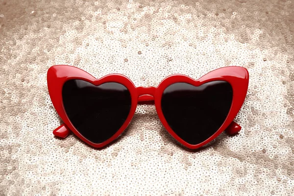Parlak arka planda kırmızı kalp şeklinde güneş gözlüğü — Stok fotoğraf